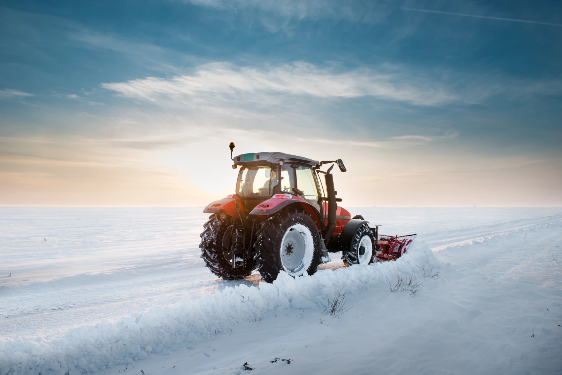 Tractor with snow-clearing equipment in a winter field
